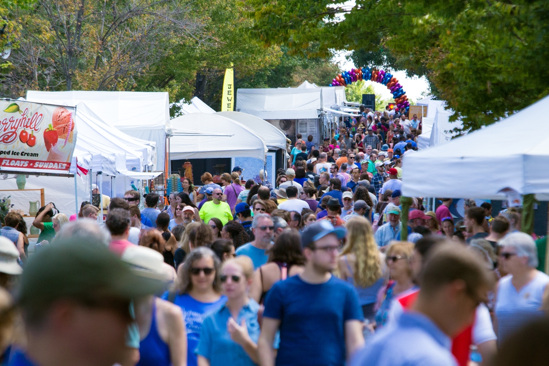 A crowd walks along a street lined with vendors during Centerfest